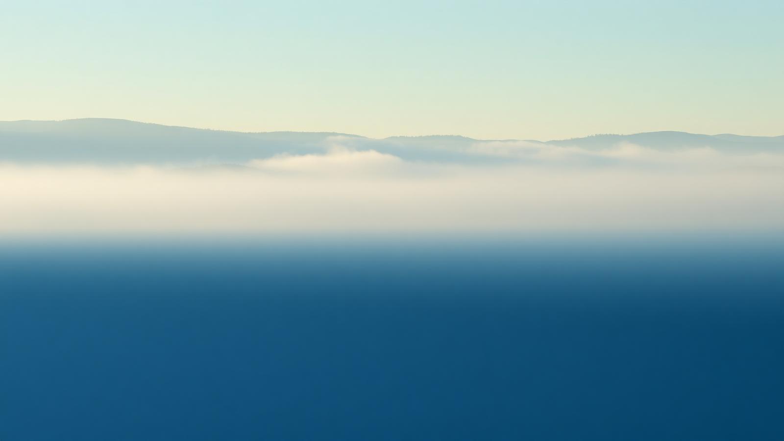 Mist over a still lake horizon
